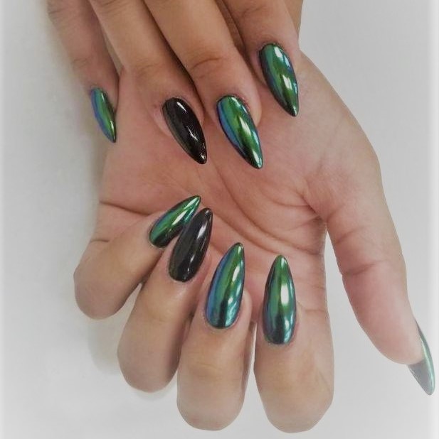 a stiletto manicure with a dark green chrome color with a
                        shiny black ring finger