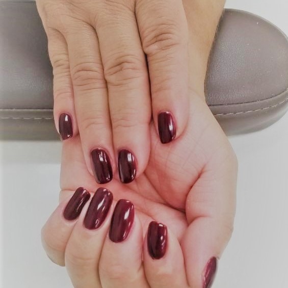 a round-tip manicure with a deep red gel polish
