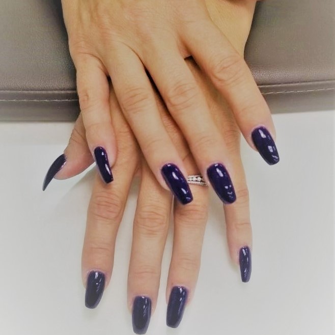 a ballerina-tip SNS dipping powder manicure in a deep
						purple color