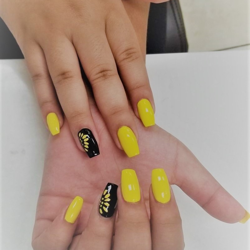 a ballerina-tip manicure with a happy yellow polish,
						featuring a sunflower design on the ring finger